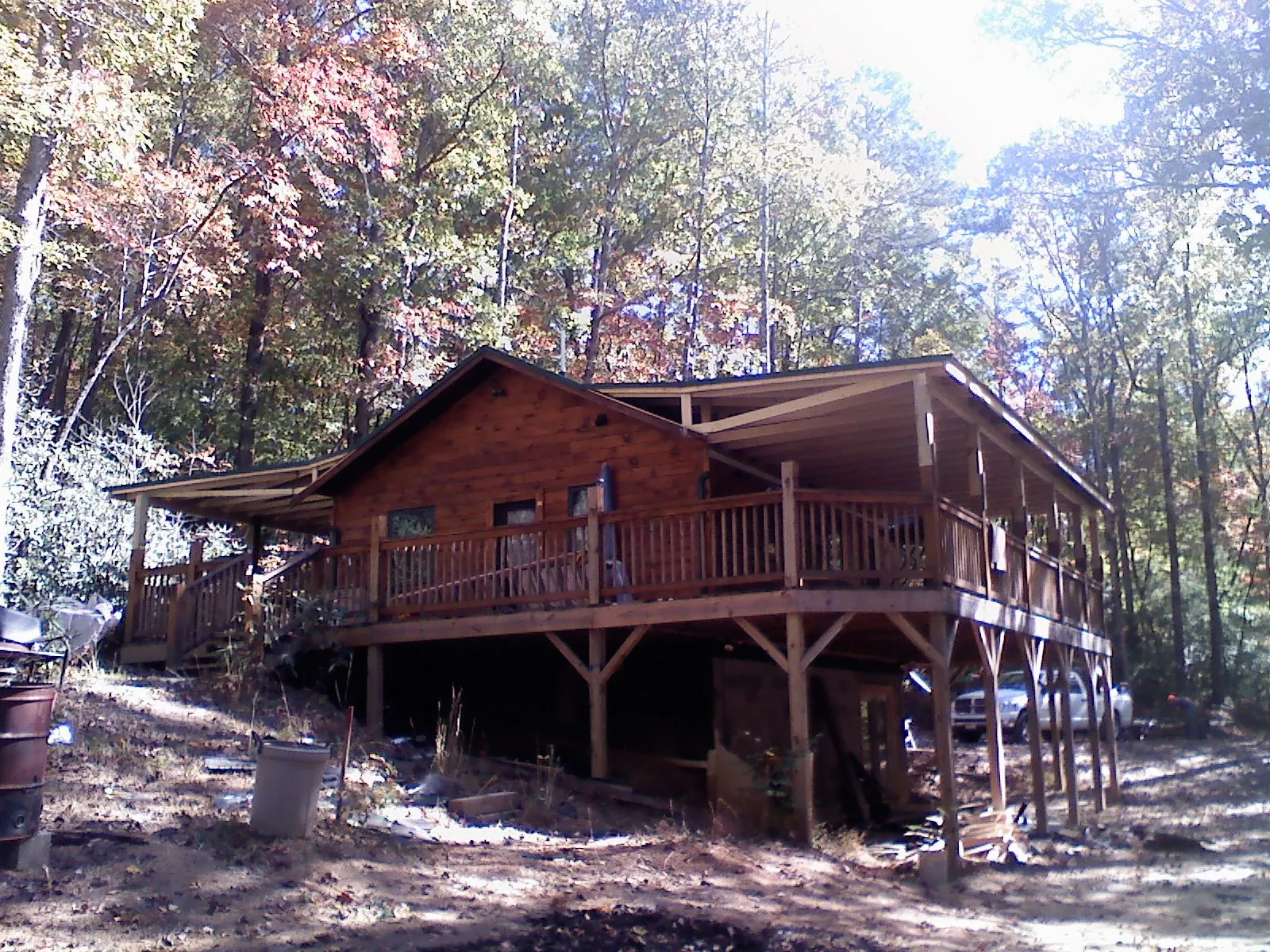 Log cabin with a wraparound porch and metal roof in the fall in Georgetown